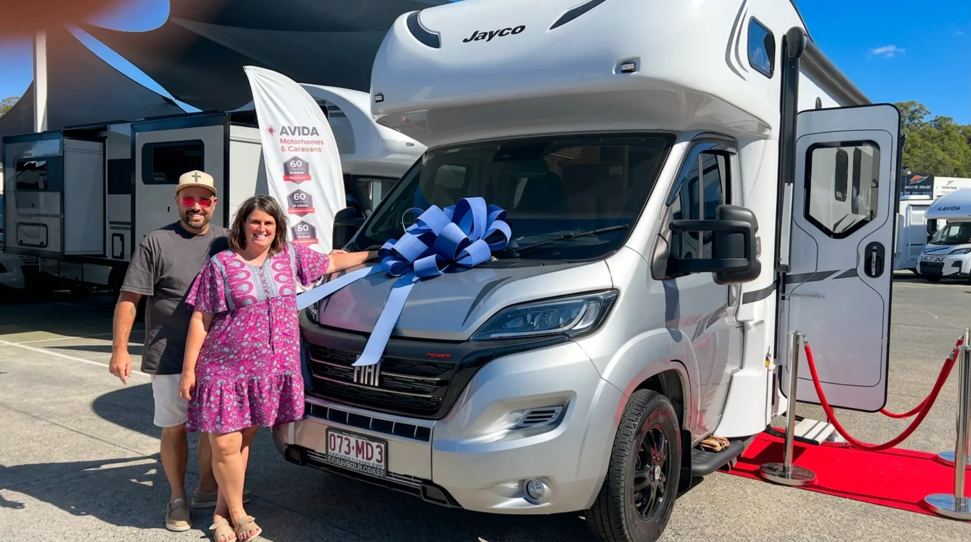 Couple celebrating motorhome delivery at Avida dealership