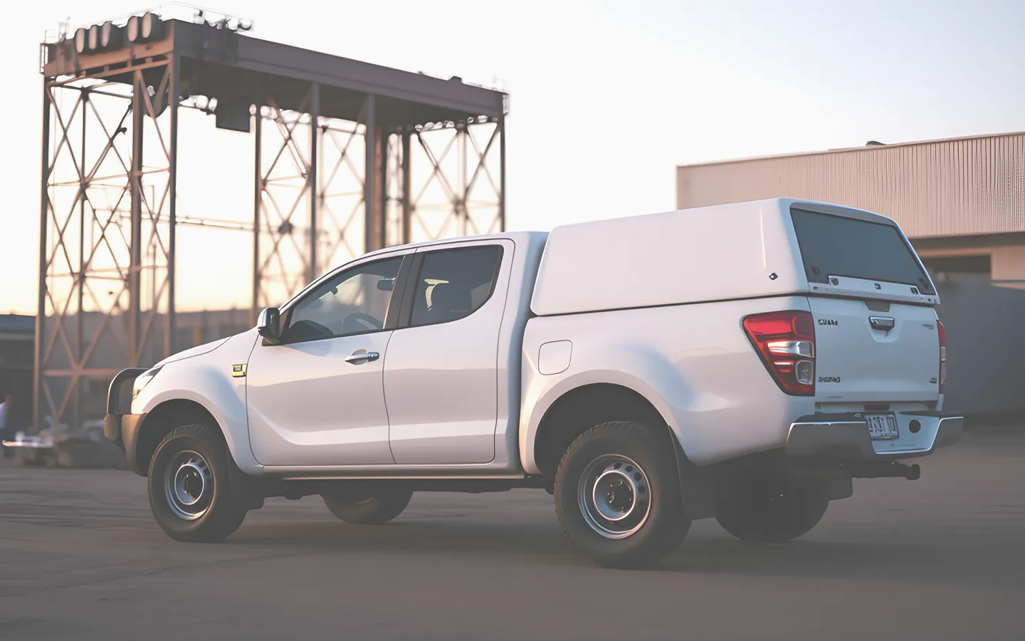 White dual cab ute with canopy parked at a worksite